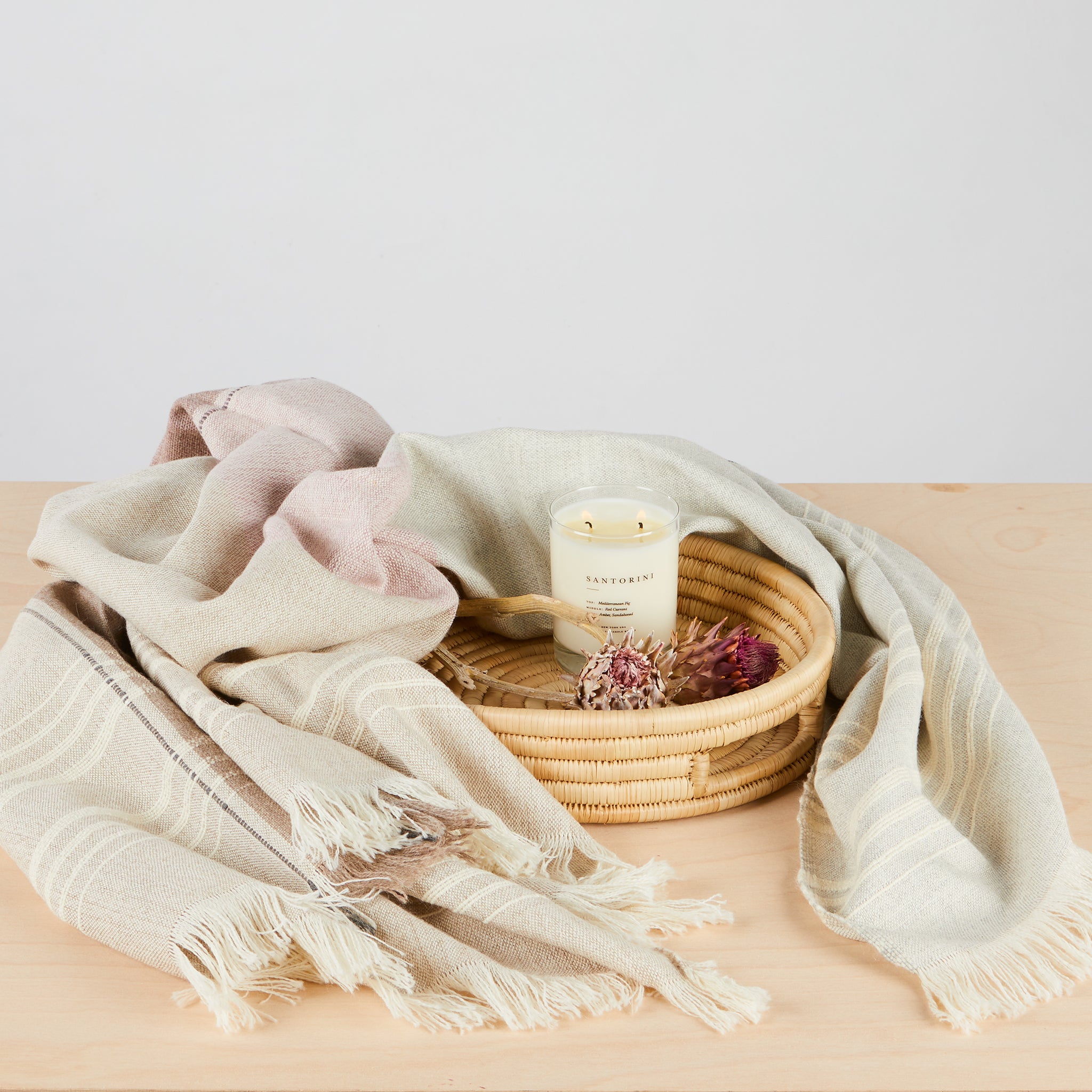 Handgewebt in Peru: Wunderschöne Baby-Alpaka Decke in der Farbkombination grau, beige, natur und altrosa mit Wimpernfransen und Hochrelief-Streifen. Ambiente Foto mit Brooklyn Candle Studio Kerze "Santorini" und Tablett "Umi". 