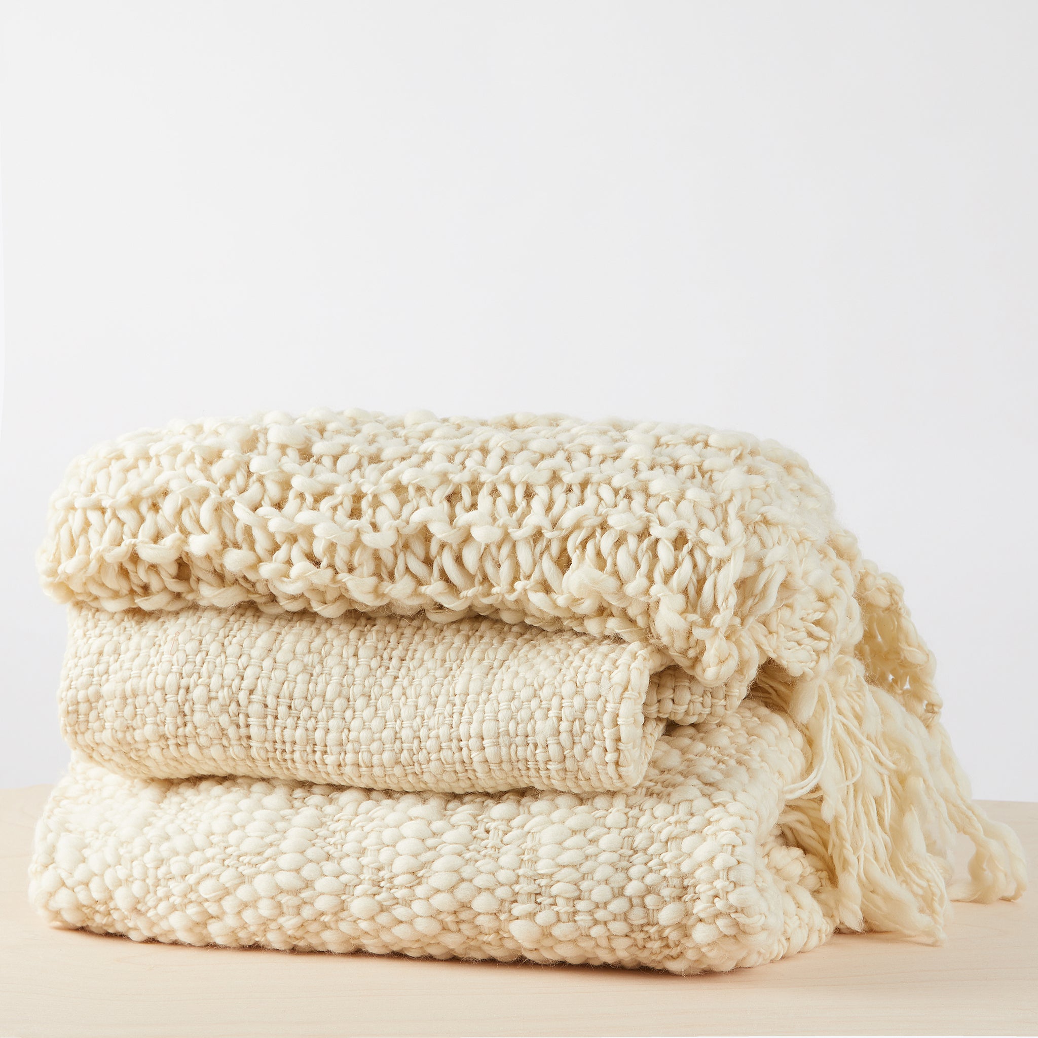 Handgewebte Merino Wolldecken Animaná und Sueno gefaltet mit einer weichen,  einzigartigen Textur mit langen Fransen