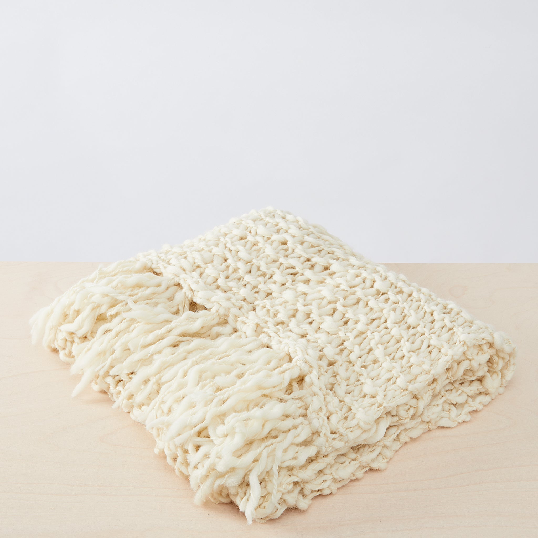 Handgewebte Merino Wolldecke Animaná,  gefaltete Ansicht mit  weicher,  einzigartiger Textur mit langen Fransen 