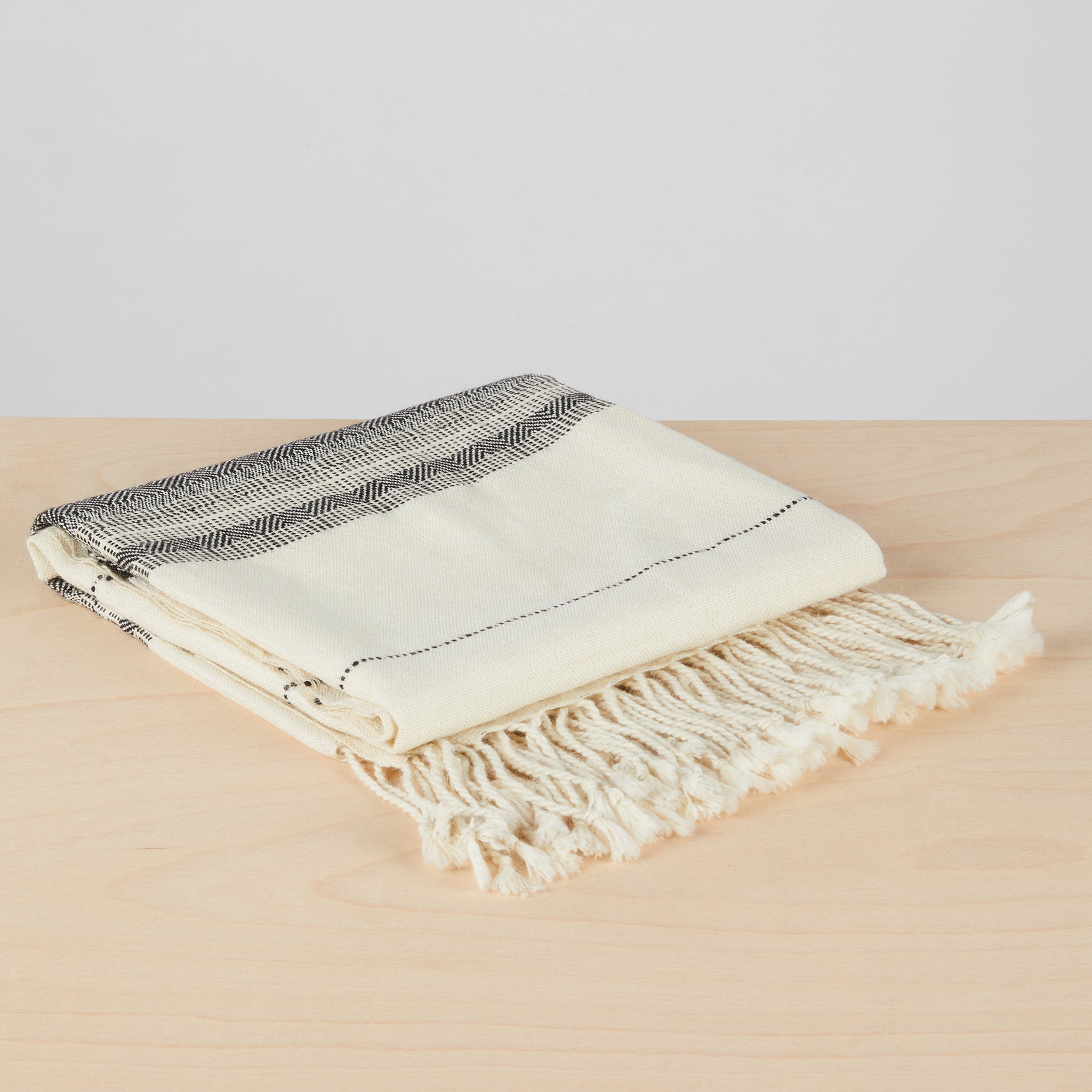 Handgewebte Alpakadecke Coya gefaltet. Besonders weiche, handgewebte, detailreiche Decke aus 100% Baby-Alpakawolle.