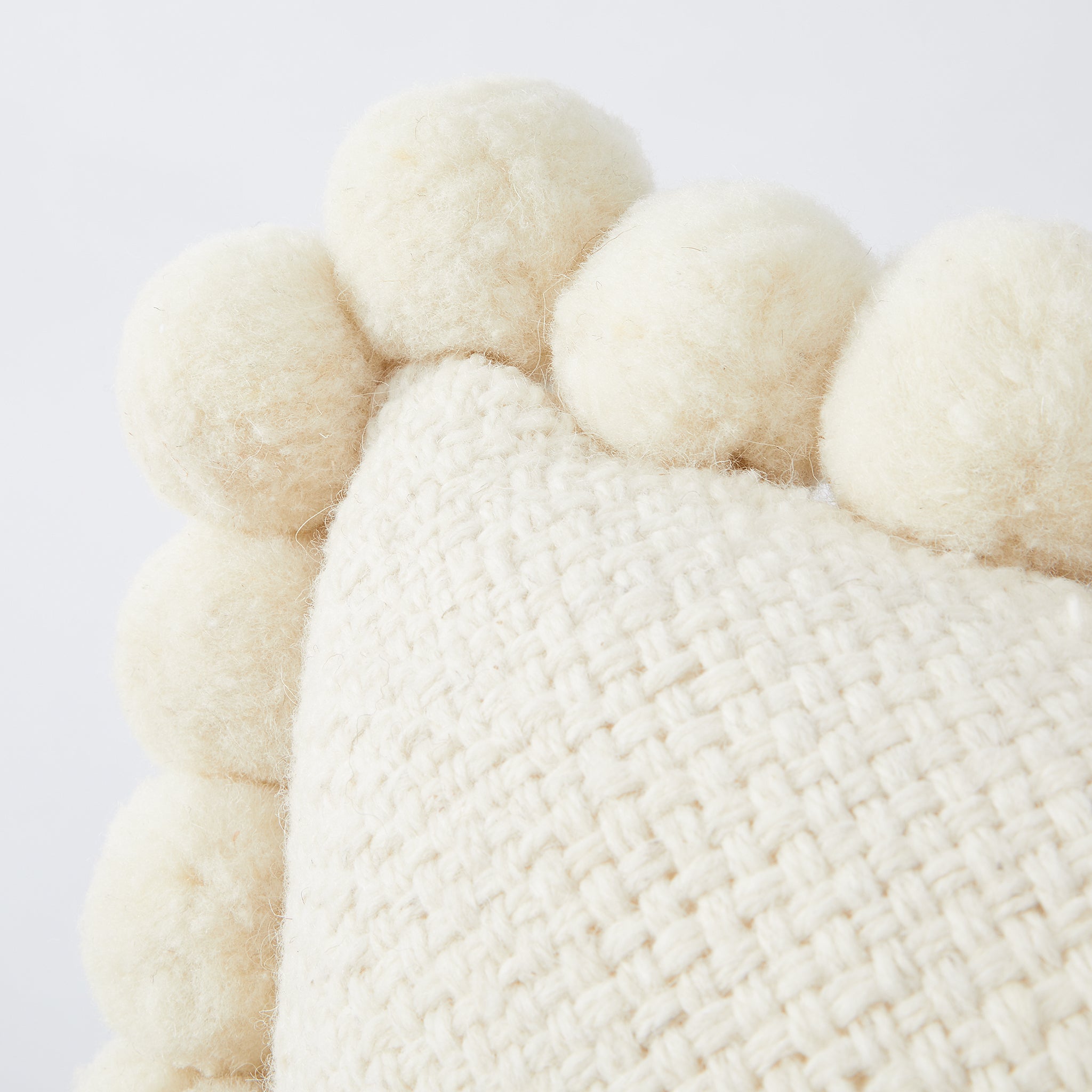 Hand-woven wool cushion PomPom detail