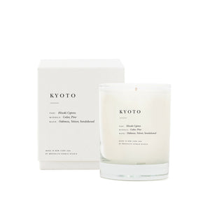 Brooklyn Candle Studio scented candle Kyoto series Escapist with packaging. A romantic homage to Kyoto in the rain, green avenues and Japanese wooden architecture. This wonderful scented candle is a meditative, calming composition of Hinoki cypress, cedar, sandalwood, vetiver and pine. Hand-poured with 100% soy wax in the small manufactory of Brooklyn Candle Studio.