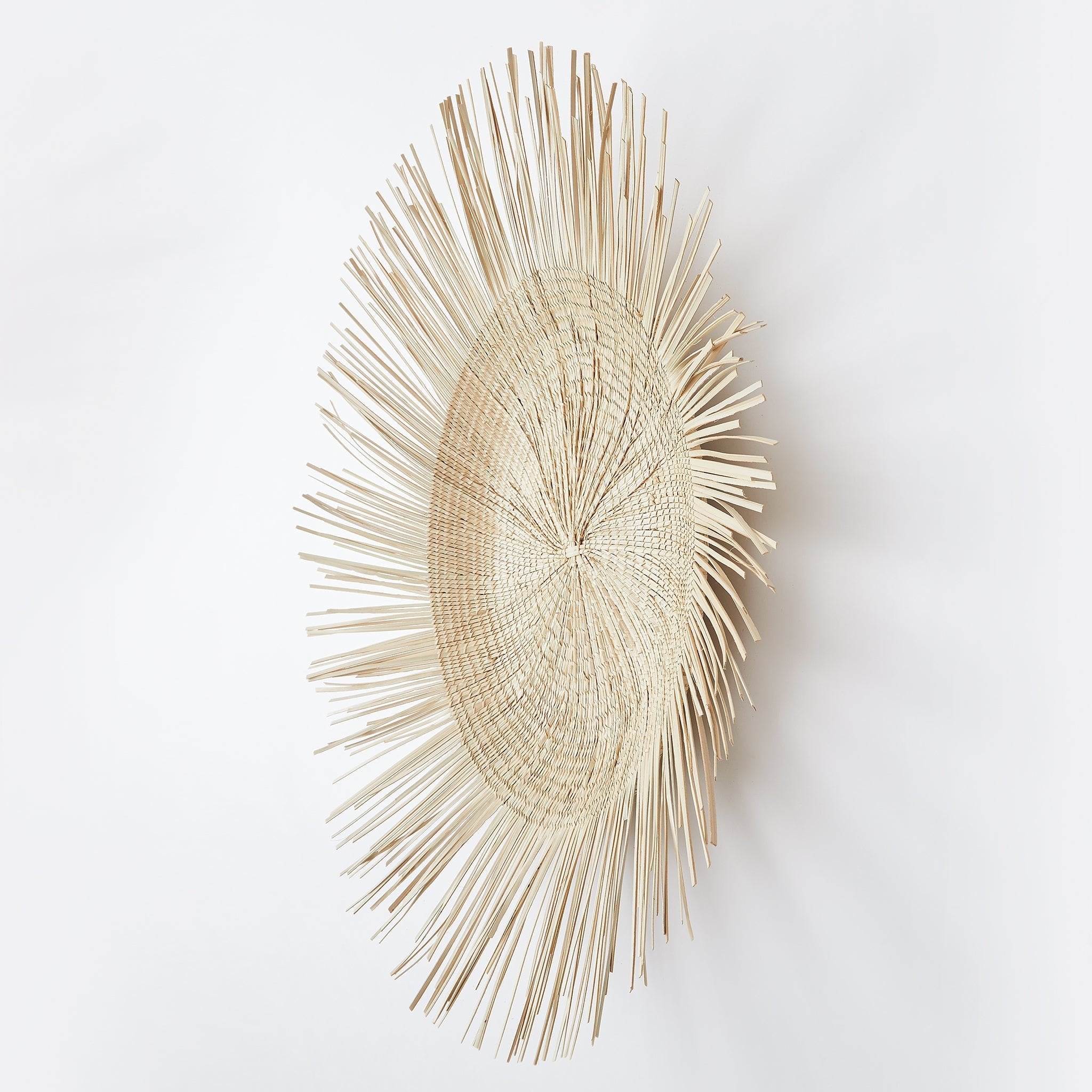 Seitenansicht mit Schattenspiel: BY NATIVE Sonnenteller klein, handgeflochten aus Palmenblättern in Malawi