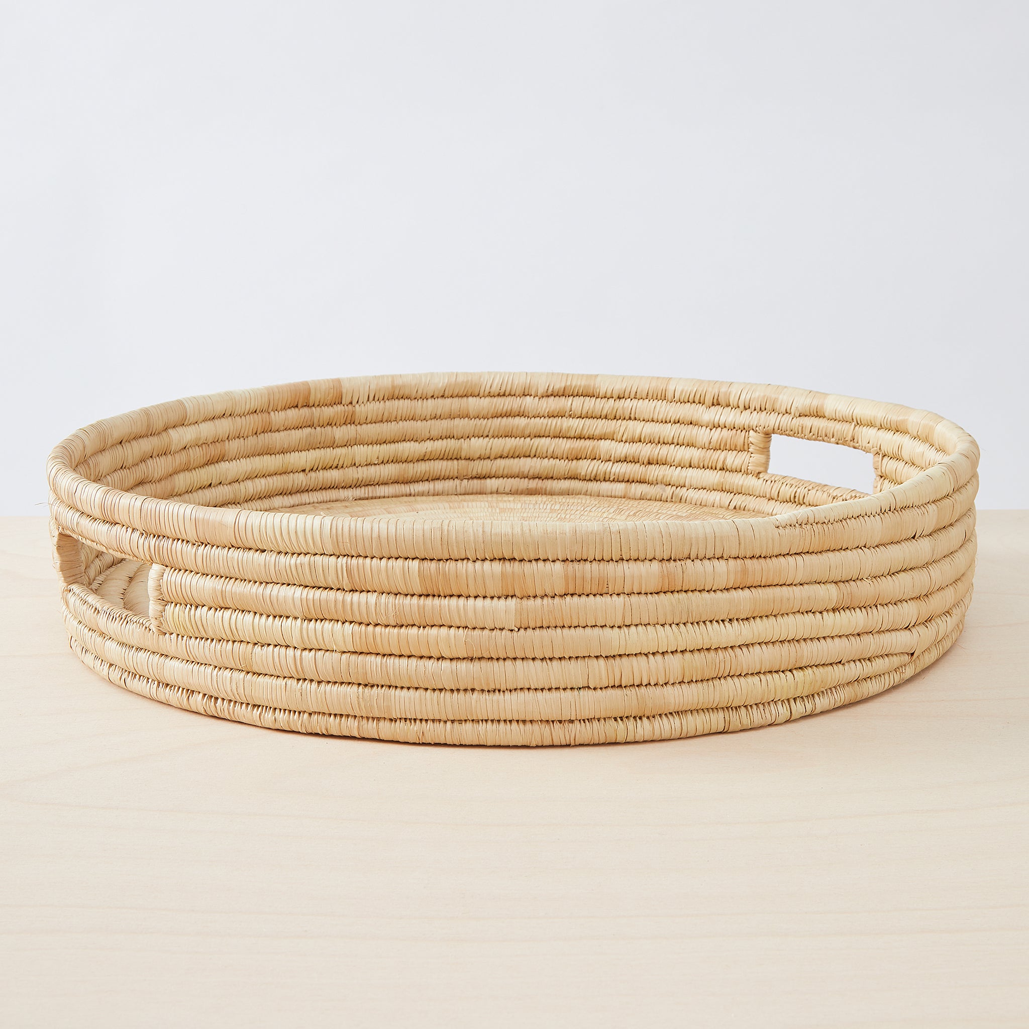 Seitenansicht Tablett "Umi". Stilvoll servieren: Das minimalistische und sehr stabile Tablett "Umi" wird sorgfältig aus Palmenblättern geflochten. Ein lässiger Allrounder für dein Zuhause.  Durchmesser: 50 cm Höhe: 10 cm