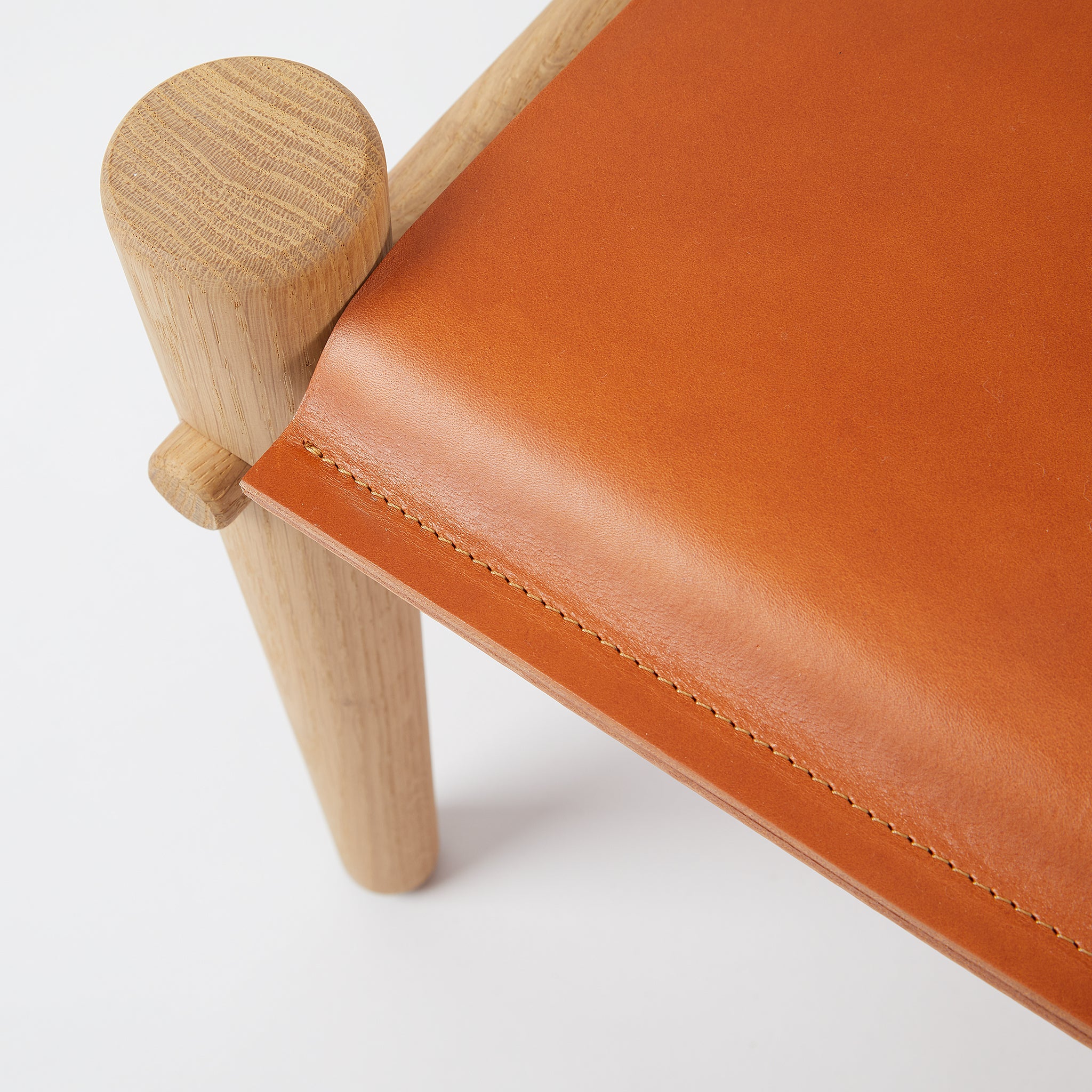 Detailaufnahme oben. Passend zu unserem Safari Sessel, oder auch als eigenständiger Hocker und Beistelltisch. Liebevoll handgefertigt aus massivem Eichenholz und luxuriösem Leder.